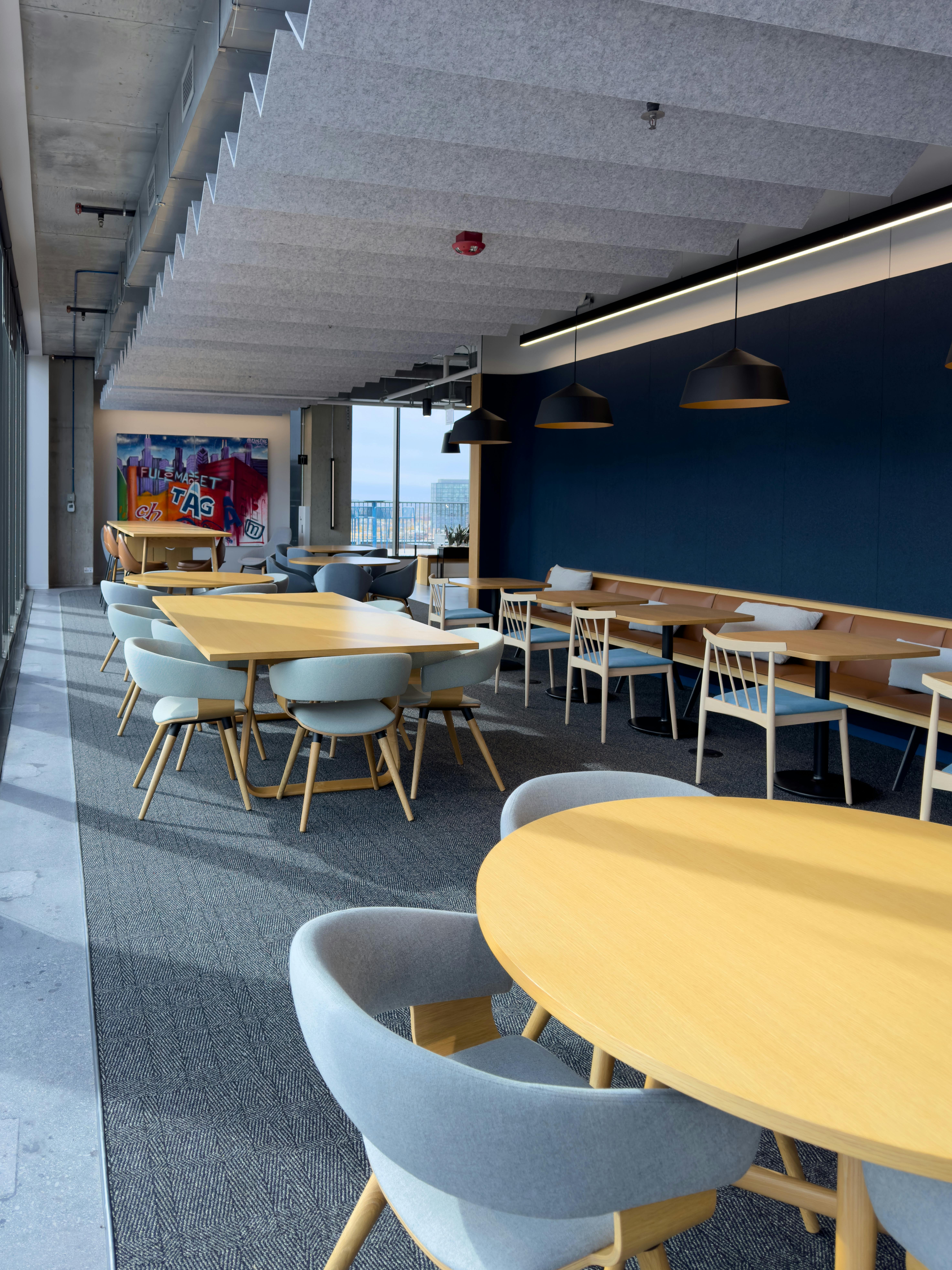 Spacious office break room with stylish seating and large windows.