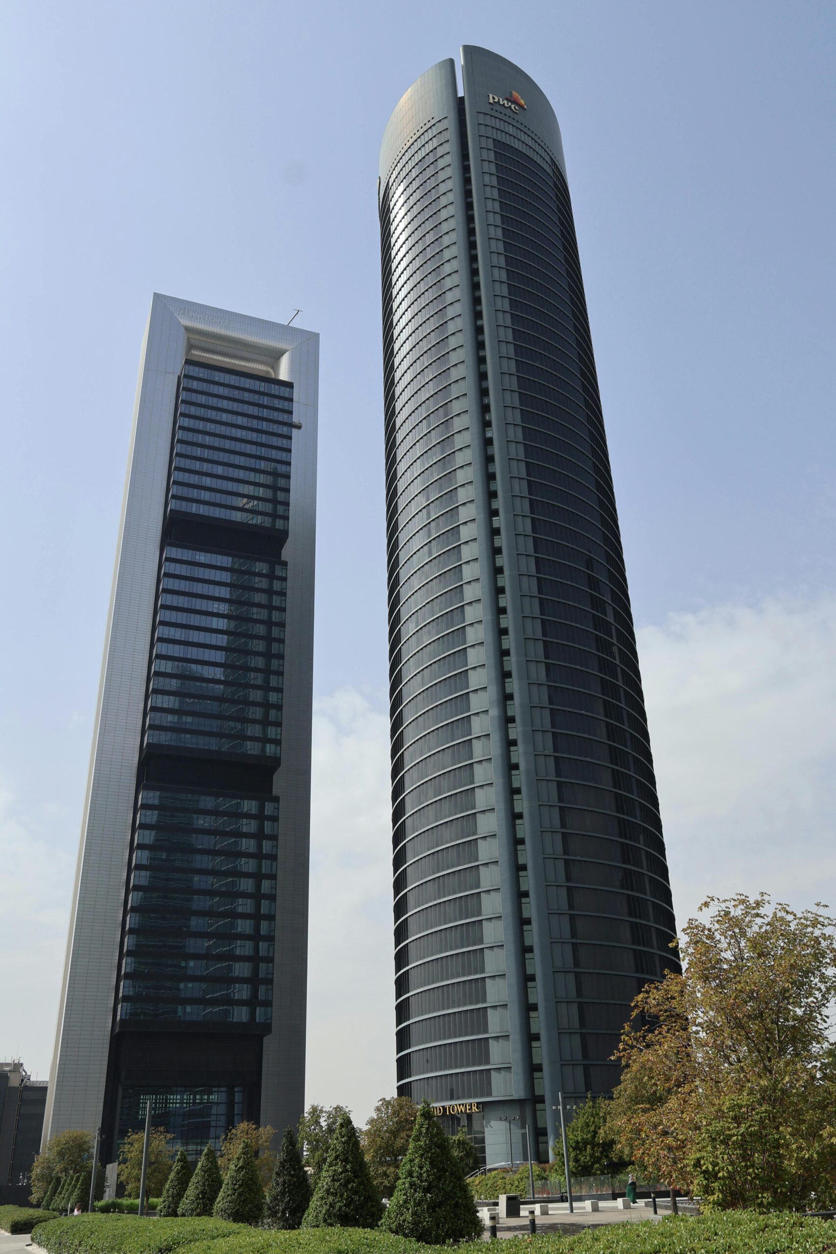 Two iconic skyscrapers in Madrid, Spain, with modern architecture and clear sky.